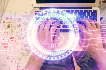 Double exposure of man's hands typing over computer keyboard and crypto currency theme hologram drawing. Top view. Blockchain concept.