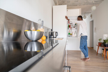 Man standing in the kitchen looking into fridge
