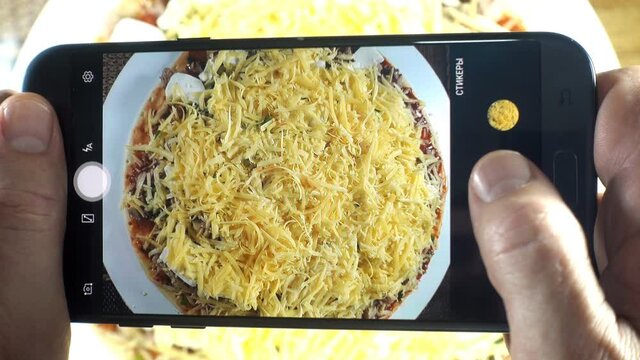 Taking a photo of a pizza with a smartphone in 4K
