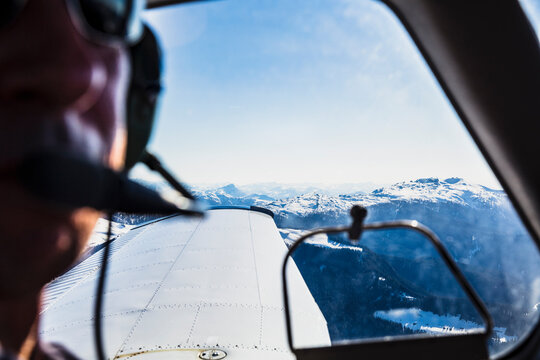 Austria, Tyrol, Steinberg am Rofan, Pilot looking through window during flight over mountain range