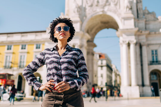 Woman wearing sunglasses standing against Praco Do Comercio in Lisbon, Portugal