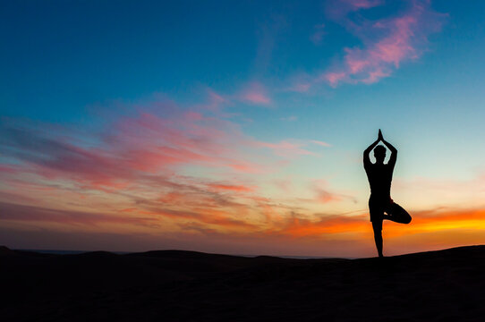 Silhouette of man doing yoga at sunset, Gran Canaria, Spain