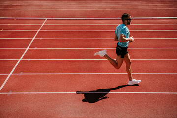 Male athlete running on tartan track