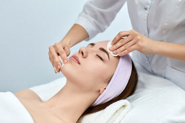 beautician cleanses skin of beautiful woman with a sponge. Perfect cleaning, spa treatment skincare face.