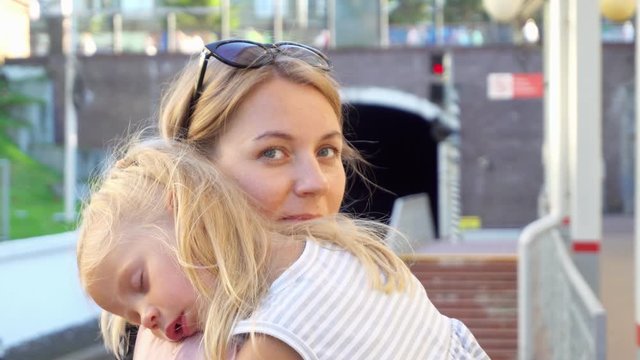 The baby sleeps in mom's arms. Baby sleeps in mom's arms and drools