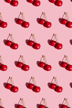 Pattern of fresh cherries on pink background