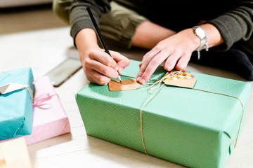 Woman's hands writing on present tag