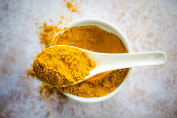 Bowl and spoon of yellow curry powder