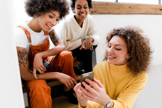 Three Friends Having Fun With Smartphone At Home