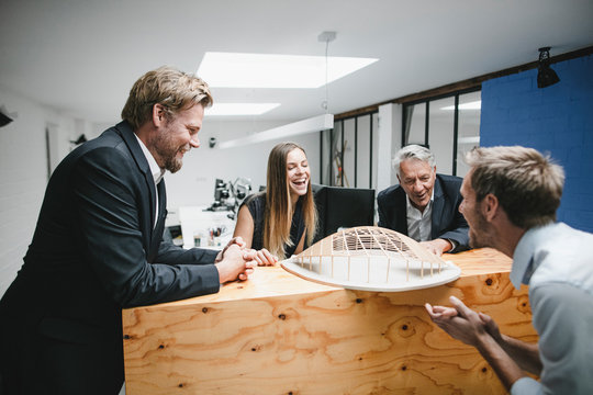 Successful business people looking at architectural model in office