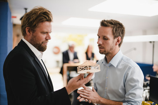 Architects looking at model of modern building