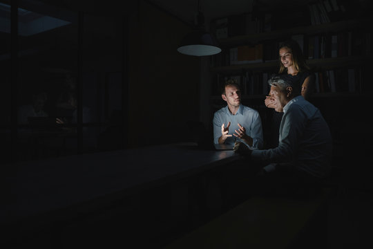 Team of business people working late in office, disussing solutions