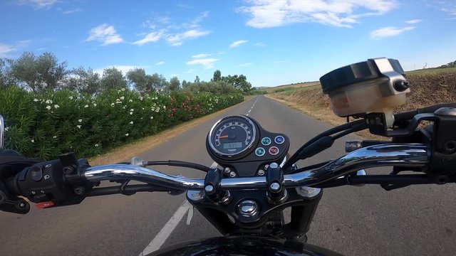 Riding an old black motorbike on a curly asphalt tarmac road driver point of view