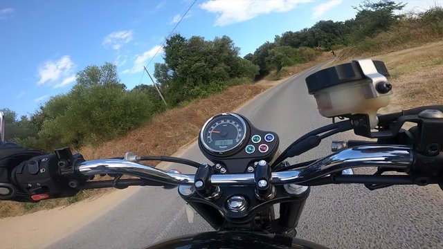 Riding an old black motorbike on a curly asphalt tarmac road driver point of view driving on a long straight