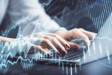 Double exposure of businesswoman hands typing on computer and forex chart hologram drawing. Financial analysis concept.