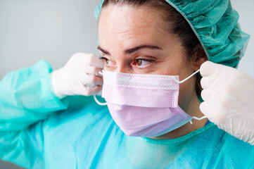 Close-up of nurse wearing surgical mask looking away in clinic