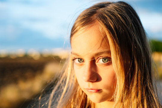 Blond girl staring with sunlight on her face
