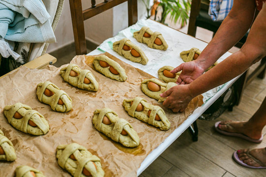 Low section of female chef arranging Mona De Pascua over paper on table in kitchen
