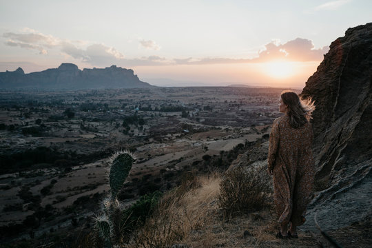 Full length of woman standing at Gheralta Mountains during sunset, Ethiopia, Central Tigray, Hawzen