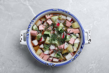 Delicious cold okroshka with kvass on grey table, top view. Traditional Russian summer soup