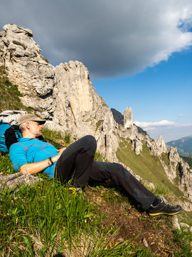 Mature man lying on Grignetta mountain against sky, European Alps, Lecco, Italy