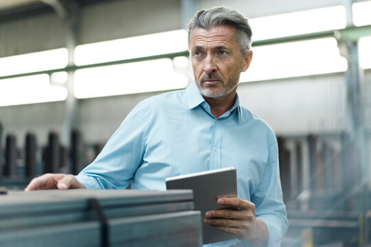 Mature businessman with tablet in a factory