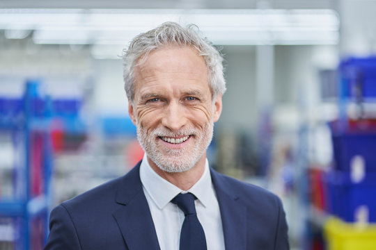 Happy mature male manager in factory