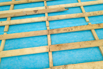 Top down detail of a wooden roof frame on a house under construction.