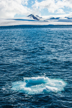 Ice floating in water with coastline of&Ocirc;&oslash;&Omega;Tabarin Peninsula in background