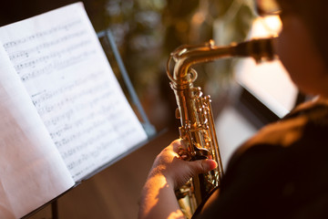 Crop view of boy exercising to play the saxophone at home