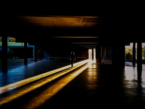 A young girl walks into the light at school into the sun