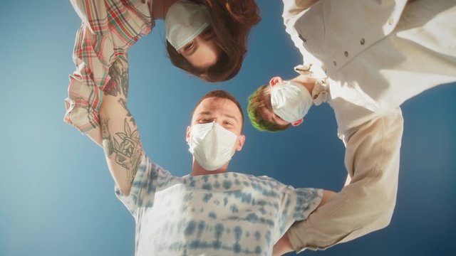 Joyful Multicultural Teenagers Standing In Circle, Young people, man and woman, medical protection safety coronavirus covid 19 masks, Low Angle. Generation z millennials have fun on party in circle