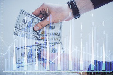 Multi exposure of financial graph drawing hologram and USA dollars bills and man hands. Analysis concept.