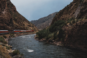 Train riding beside the arkansas river in the royal gorge on a sunny day