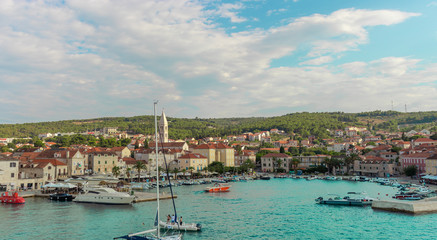 Fototapeta na wymiar Supetar Croatia August 2020 Beautiful picturesque view of the town of Supetar, as seen from the car ferry from up high. Warm summer day on the small coastal town on the island of Brac