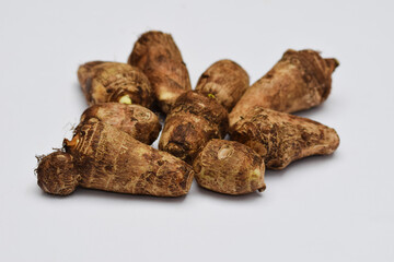Whole Taro root or Colocasia esculenta raw root vegetable also known as Arbi in India on white background