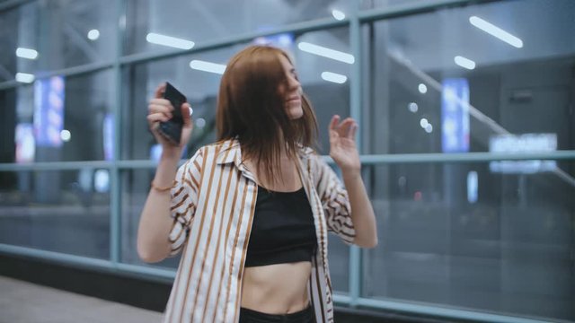Young attractive redhead hipster woman dance on street at night. 
