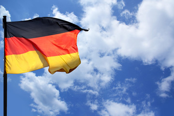 flag of the federal republic of Germany freely flutters in the wind against a blue sky, , concept of tourism, economy, politics, emigration, business