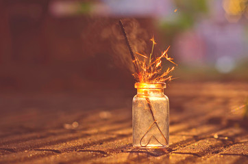 Tiny jar with sparkler sparkling with smoke and heart shape