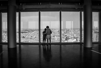 Fototapeta na wymiar People admiring the Milan skyline from the 43-storey of the modern glass Lombardy Building (Palazzo Lombardia), a 161 m tall skyscraper