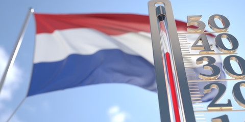 Thermometer shows high air temperature against blurred flag of the Netherlands. Hot weather forecast related 3D rendering
