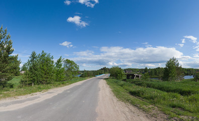 Country road in the village. summer day. bridge on the horizon