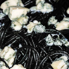 Black Italian spaghetti, pasta with blue cheese with mold and olive oil, macro picture.