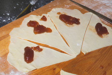 Raw dough slices with jam for croissant baking. pastry cooking