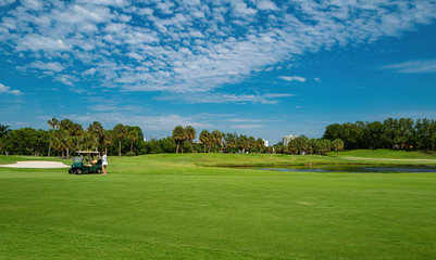 Fototapeta na wymiar Golf club in the USA. Nature and sport. Panorama View of Golf Course with putting green. Golf course with a rich green turf beautiful scenery.