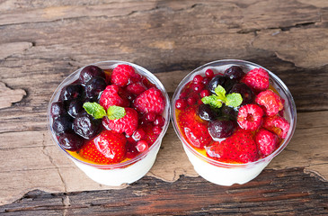 Fruit yogurt has strawberry raspberry blueberry canberry and honey greek white clean In bowl on a wooden background from top view.
