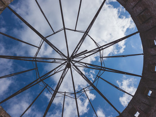 Obraz premium View of the sky through a ruined roof construction. steel frame for roof mounting