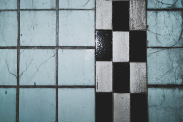 Cracked tiled wall in an old abandoned building. grunge background
