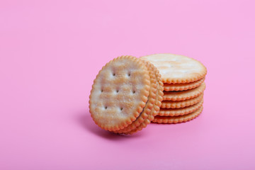 Cream sandwich biscuits on pink background