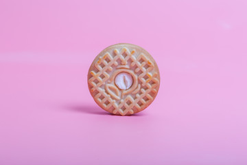 Cream sandwich biscuits on pink background